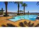 Resort-style pool surrounded by palm trees, gazebos, and stunning mountain views on a clear, sunny day at 21 Via Visione # 206, Henderson, NV 89011