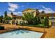 Community pool and building exterior featuring lush landscaping, tall trees and wrought iron fencing at 21 Via Visione # 206, Henderson, NV 89011