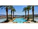 Stunning infinity pool surrounded by palm trees and lush landscaping, offering breathtaking views of the lake and mountains at 21 Via Visione # 206, Henderson, NV 89011