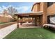 Well-kept backyard featuring a covered patio, artificial turf, and privacy walls at 2307 Tuscarora Ct, Las Vegas, NV 89142