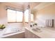 Bright bathroom featuring a soaking tub, double windows, and a vanity with a sink at 2383 Thayer Ave, Henderson, NV 89074