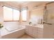 Bright bathroom featuring a soaking tub, double windows, and a vanity with a sink at 2383 Thayer Ave, Henderson, NV 89074