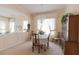 A dining room with carpet, wood furniture, chandelier, and half-wall to living room space at 2383 Thayer Ave, Henderson, NV 89074