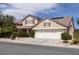 Charming two-story home with a two-car garage, desert landscaping, and a beautiful tan stucco exterior at 2383 Thayer Ave, Henderson, NV 89074