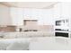 Bright kitchen features white cabinets, tile backsplash, and modern appliances at 2383 Thayer Ave, Henderson, NV 89074