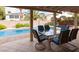 Outdoor dining area on a covered patio, overlooking a sparkling pool and a beautifully landscaped backyard at 2383 Thayer Ave, Henderson, NV 89074