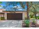 Attached two-car garage with mature trees and professional landscaping at 2479 Domingo St, Las Vegas, NV 89121