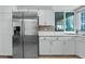 Modern kitchen with stainless steel refrigerator, white cabinets and drawers, and a tiled backsplash at 2479 Domingo St, Las Vegas, NV 89121