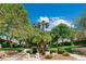 Landscaped median with lush greenery, trees and an American flag displayed beneath a blue sky at 2479 Domingo St, Las Vegas, NV 89121