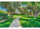 Scenic community pathway lined with mature trees and green lawns leading to a beautiful property at 2479 Domingo St, Las Vegas, NV 89121