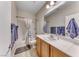 Well-lit bathroom showcasing a vanity, mirror, and shower-tub combination with a shower curtain at 2501 Celestial Light Dr, Henderson, NV 89044