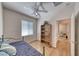 Cozy bedroom with wood flooring, ceiling fan, a window for natural light, and furnished with a comfortable bed at 2501 Celestial Light Dr, Henderson, NV 89044