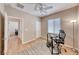Bright room featuring wood floors, a ceiling fan, and an adjacent room, creating a versatile space at 2501 Celestial Light Dr, Henderson, NV 89044