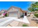 Inviting front exterior with desert landscaping, neutral paint, and a two-car garage at 2501 Celestial Light Dr, Henderson, NV 89044