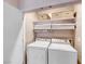 Efficient laundry area with stacked washer and dryer, complemented by storage shelves and baskets at 2501 Celestial Light Dr, Henderson, NV 89044