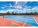 Brightly colored tennis court with blue and red surfaces ready for a game under a clear, sunny sky at 2501 Celestial Light Dr, Henderson, NV 89044
