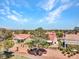 An aerial view of a neighborhood showcasing houses with red tile roofs amid desert landscaping under a blue sky at 2829 Golf Links Dr, Las Vegas, NV 89134