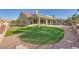 Backyard with synthetic grass, rock landscaping, and a covered patio at 2829 Golf Links Dr, Las Vegas, NV 89134