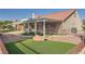 Landscaped backyard featuring synthetic grass and a covered patio at 2829 Golf Links Dr, Las Vegas, NV 89134