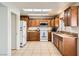 Traditional kitchen with wood cabinetry, granite counters, and white appliances at 2829 Golf Links Dr, Las Vegas, NV 89134
