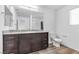 Modern bathroom with granite countertops, dark wood cabinets and plenty of lighting at 2846 Cerulean Stars Ln # 1, Las Vegas, NV 89183