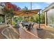 Backyard patio with outdoor seating, dining area, and landscaped garden under a shaded pergola at 3004 Astoria Pines Cir, Las Vegas, NV 89107