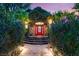Front door with a brick archway, lush greenery, a red door, and a stone walkway at 3004 Astoria Pines Cir, Las Vegas, NV 89107