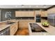 Spacious kitchen featuring light wood cabinetry, stainless steel appliances, and a central island with a cooktop at 3004 Astoria Pines Cir, Las Vegas, NV 89107