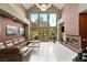 Open living room with tile flooring, a modern fireplace, and a brown leather sofa at 3004 Astoria Pines Cir, Las Vegas, NV 89107