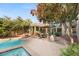 Beautiful backyard pool area with lounge chairs, outdoor seating, and lush landscaping at 3004 Astoria Pines Cir, Las Vegas, NV 89107
