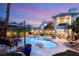 Twilight view of the backyard pool area with sparkling water, lush landscaping, and patio furniture at 3004 Astoria Pines Cir, Las Vegas, NV 89107