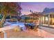 Inviting backyard oasis with a sparkling pool, patio dining area, and lush landscaping at 3004 Astoria Pines Cir, Las Vegas, NV 89107