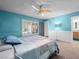 Bright bedroom showcases a ceiling fan, carpet floors, large closets, and unique blue walls at 3212 Silver Saddle St, Las Vegas, NV 89169