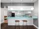 Bright kitchen with a turquoise countertop and pendant lighting above the breakfast bar at 3212 Silver Saddle St, Las Vegas, NV 89169