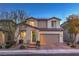 Charming two-story home with a well-maintained front yard, beautiful plants, and a two-car garage at dusk at 3213 Molinos Dr, Las Vegas, NV 89141