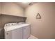 Bright laundry room features a Whirlpool washer and dryer and convenient shelving for storage at 3213 Molinos Dr, Las Vegas, NV 89141