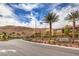 Picturesque community entrance with lush landscaping, palm trees, and scenic mountain views at 3213 Molinos Dr, Las Vegas, NV 89141