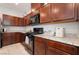 Kitchen with dark wood cabinets, granite countertops and black appliances at 3221 Pergusa Dr, Henderson, NV 89044