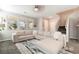 Bright living room featuring a plush sofa, large windows, and stylish decor, adjacent to the staircase at 3221 Pergusa Dr, Henderson, NV 89044