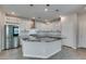 Kitchen featuring large island with black granite countertop, stainless fridge, and pendant lighting at 3270 Palindrome Ave, Henderson, NV 89044