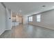 Open-concept living room featuring modern gray flooring, white walls, and a view to the kitchen at 3270 Palindrome Ave, Henderson, NV 89044