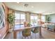 Bright dining room with a large table, green velvet chairs, and plenty of natural light at 3389 La Cura Ave # Lot 43, Las Vegas, NV 89141