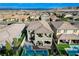 Aerial view of a backyard with a pool, patio, outdoor kitchen, covered seating area and mountain views at 361 Cooper Hawk Ct, Las Vegas, NV 89138