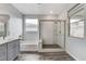 Bright bathroom featuring a soaking tub, glass-enclosed shower, and stylish gray vanity at 361 Cooper Hawk Ct, Las Vegas, NV 89138