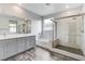 Bathroom featuring a soaking tub, glass-enclosed shower, and stylish gray double vanity at 361 Cooper Hawk Ct, Las Vegas, NV 89138