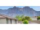 Red Rock Canyon can be seen rising behind the roofline of this home in the desert landscape at 361 Cooper Hawk Ct, Las Vegas, NV 89138