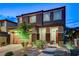 Two-story home with a well-manicured front yard, brick accents, covered porch, and two-car garage at 361 Cooper Hawk Ct, Las Vegas, NV 89138