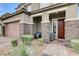 Charming front entrance showcasing a well-manicured front yard with desert landscaping and a covered porch with seating at 361 Cooper Hawk Ct, Las Vegas, NV 89138