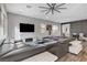 Bright living room with a large sectional sofa, TV, and ample natural light from the windows at 361 Cooper Hawk Ct, Las Vegas, NV 89138