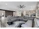A large gray sectional anchors the spacious open-concept living area with a statement wall and modern kitchen at 361 Cooper Hawk Ct, Las Vegas, NV 89138